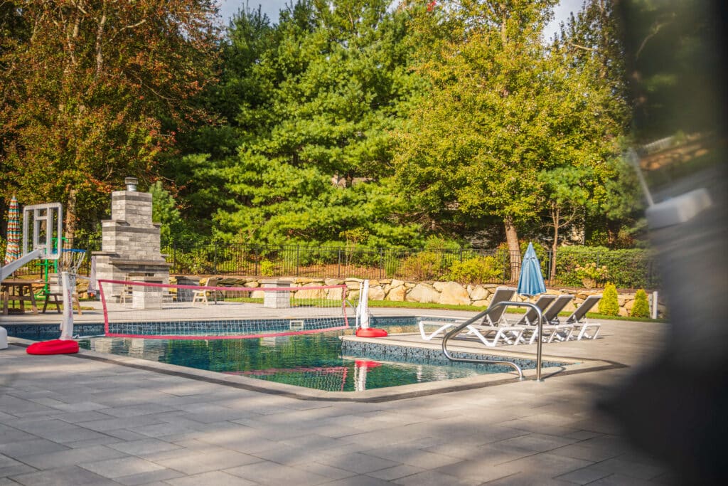 Custom fencing around an outdoor pool in a residential backyard, Rhode Island.